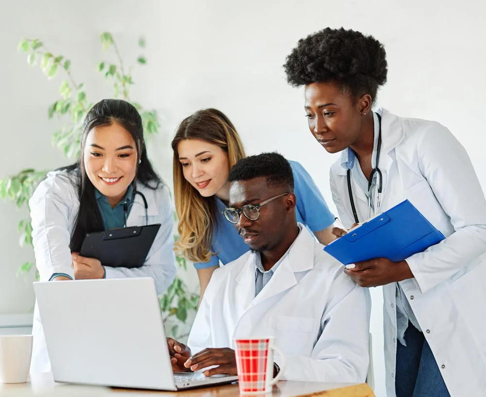 Group of young student doctors viewing a laptop