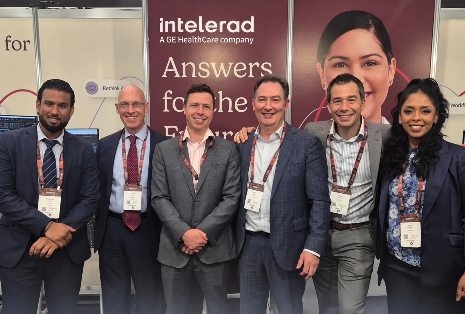 Six colleagues standing together for a photo in front of an Intelerad branded trade show display.